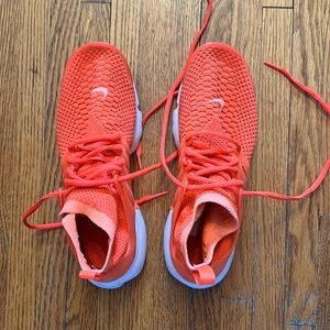 Great pair of bright orange Nike running shoe.